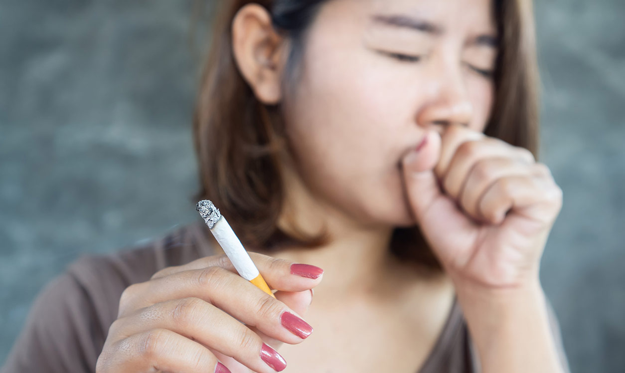 Woman smoking and coughing